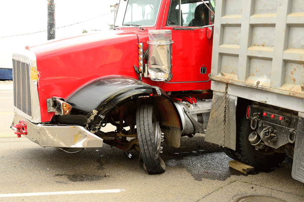 Image of red truck in an accident and the tyre is busted