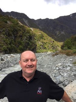 Image of a person standing with mountains in the background