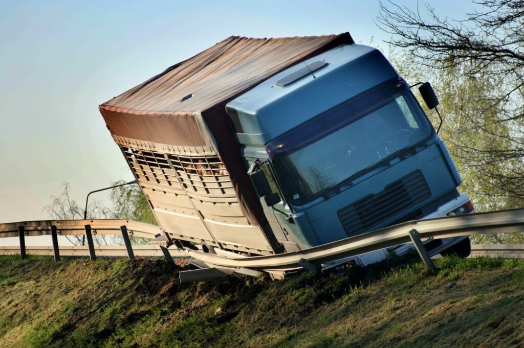 Image of a truck tilted towards the road railing on a hilly road