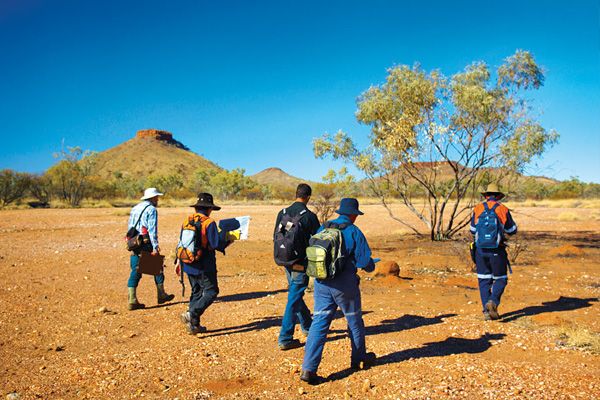 Image of workers carrying bags and walking in an isolated area